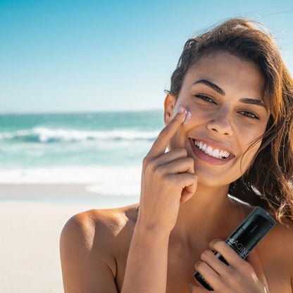 Frau trägt Onyx Anti-Aging Gesichtsbräuner am Strand auf