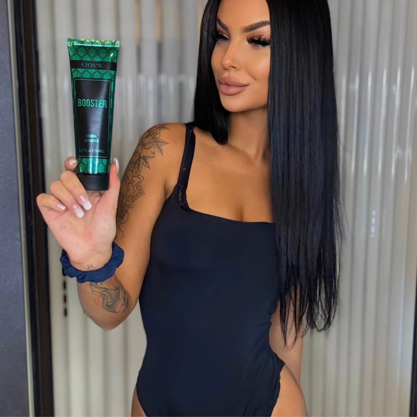 Model holding an Onyx Booster Original Intensifier tube in front of a sunbed.