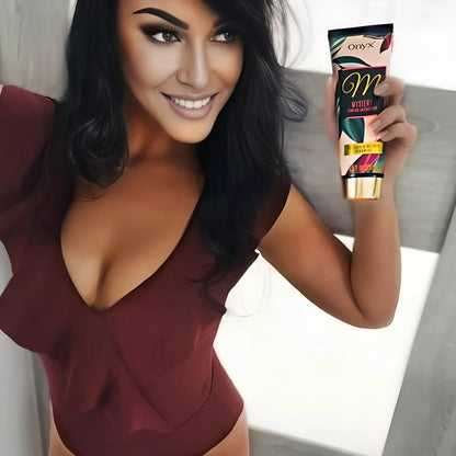 Model in burgundy dress holding Onyx Mystery tanning accelerator cream, smiling